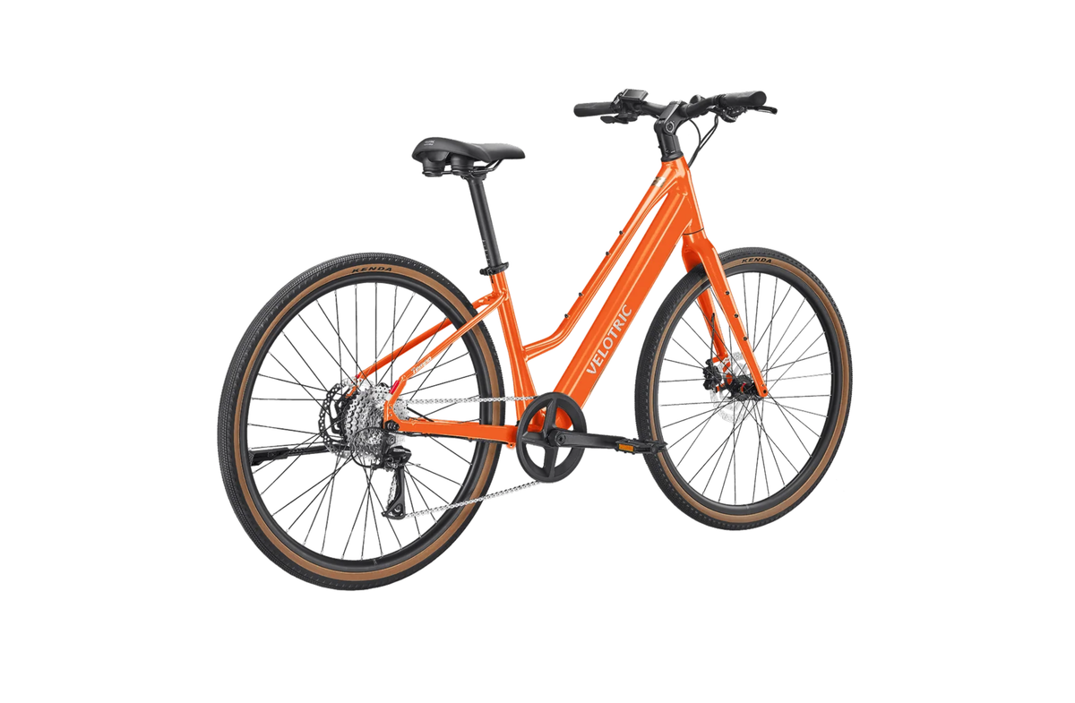 Velotric Tempo Mid-Step in Sunset Tangerine, three-quarter view (second angle) — Zeus eBikes Canada