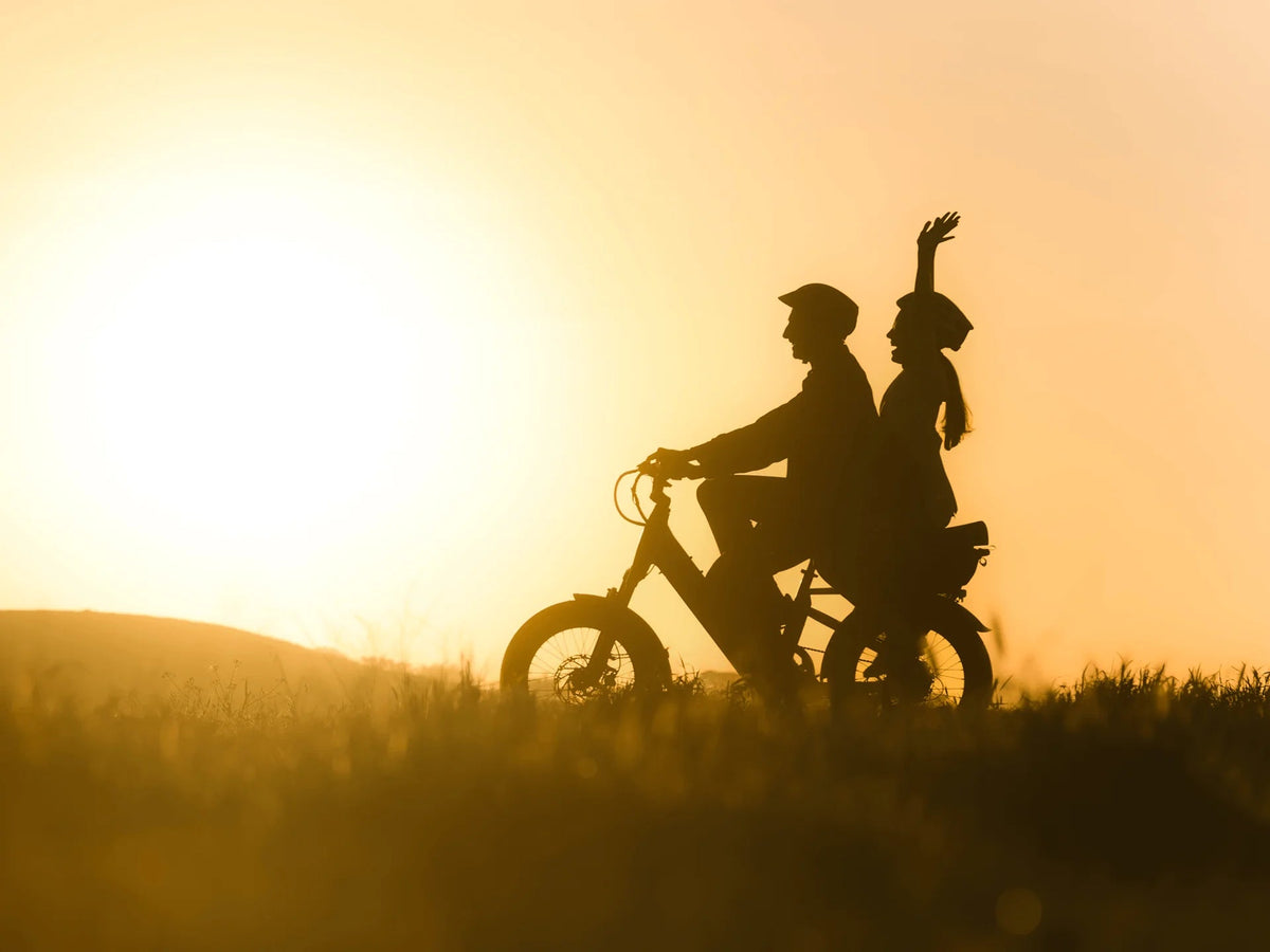 Silhouette of an adult and a child on a Velotric GoMad at sunset (Velotric photo) — Zeus eBikes Canada