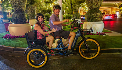 Two adults riding the Greattan L passenger trike at night (image: Addmotor)