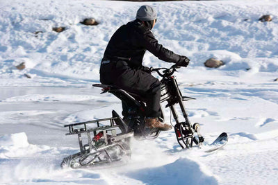 Rider on a Riding Times GT73 Pro fitted with the snow track kit crossing a frozen lake — Zeus eBikes Canada