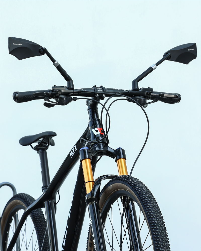 Both West Biking mirrors fitted to the flat handlebar of a mountain bike with a gold-stanchion suspension fork — Zeus eBikes Canada