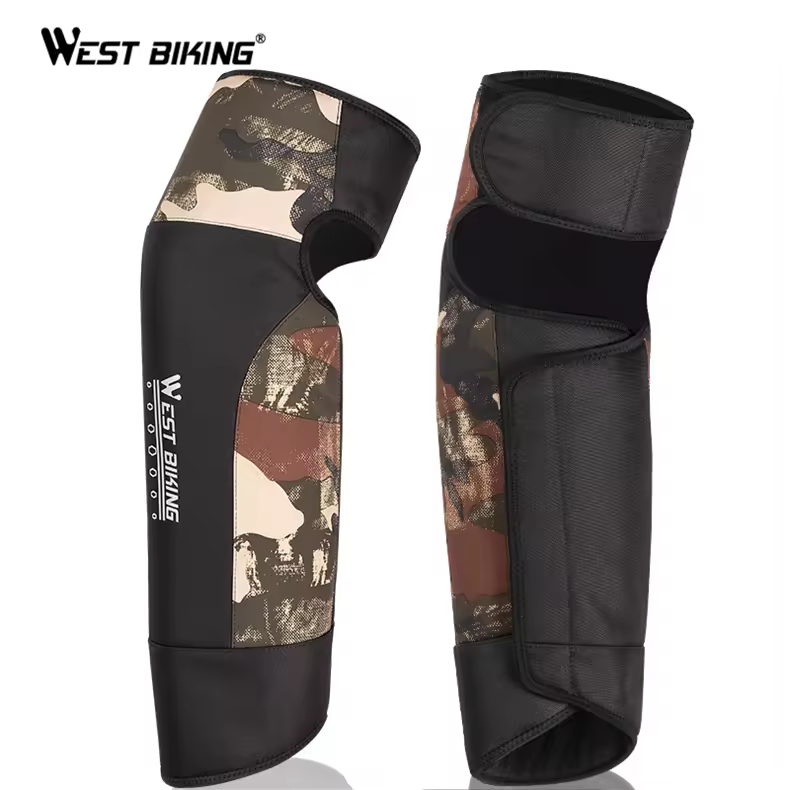 Pair of West Biking winter leg covers in brown camo with black panels: one seen from the front with white WEST BIKING lettering, one from the back with a wide strap near the top and a long flap down the back — Zeus eBikes Canada